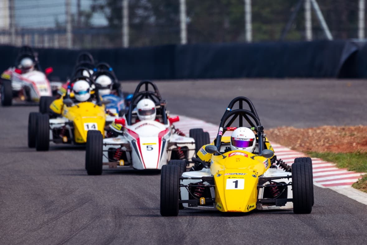 Formula cars racing in a close group